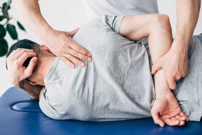 Person seated at a desk with relaxed jaw posture while gently stretching the neck and shoulders.